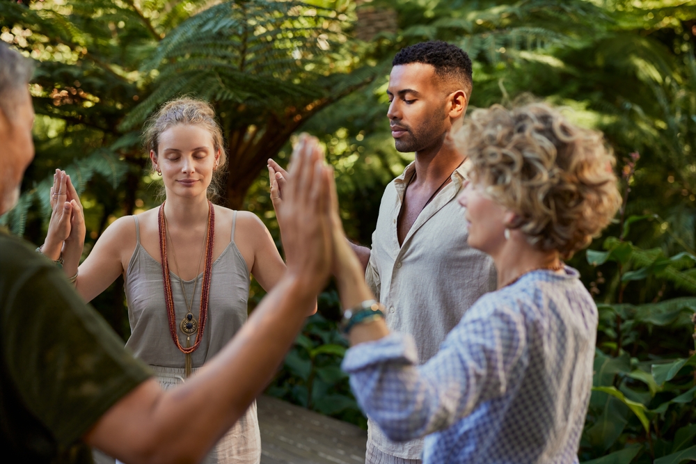 Groupe diversifié de personnes debout en cercle, se tenant la main ensemble