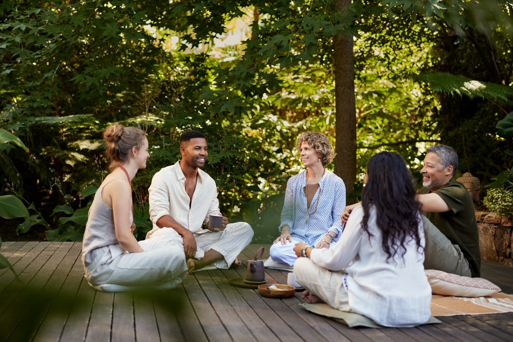 Groupe diversifié de personnes appréciant leur compagnie mutuelle en étant assises ensemble