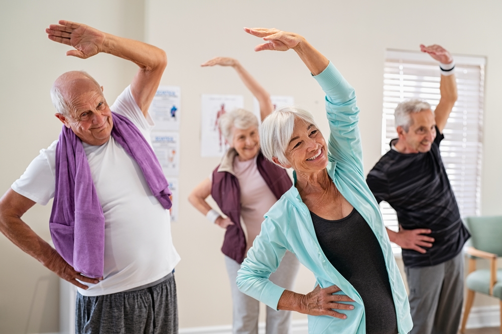  Groupe de personnes âgées faisant des exercices d'étirement ensemble dans un centre de retraite