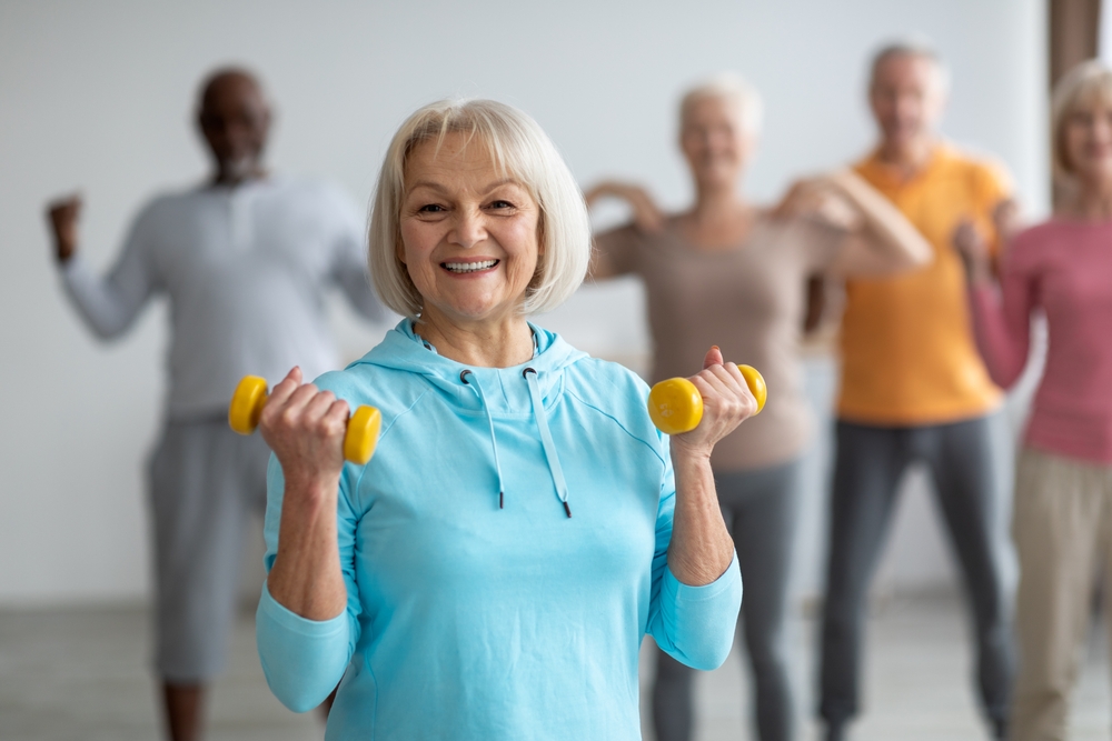 Groupe multiracial de personnes âgées en tenue de sport pratiquant des exercices de renforcement musculaire